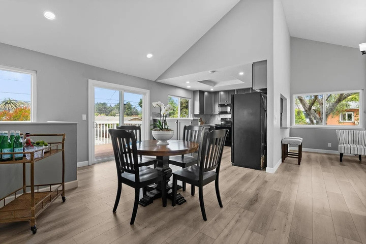 The house before renovation: a dining table in a family room closed off from the kitchen by a wall.